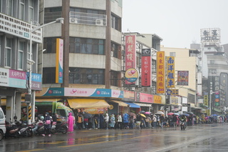 屏東都城隍廟發錢母  人龍雨中綿延數公里