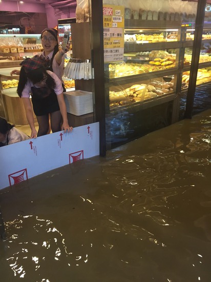 大雨傾洩 台北文山區多路段水淹及膝 | 萬芳醫院附近麵包店急忙在門口檔水