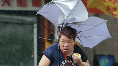 繼梅姬肉包大媽 香港也出現"星巴克大叔"! | 梅姬颱風襲台，大媽「小甜甜」在狂風暴雨中嗑肉包登上國際媒體(翻攝AP)