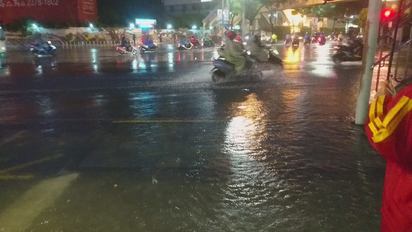 【影】暴雨直擊! 三重水淹半輪胎高 | 民眾涉水走過。