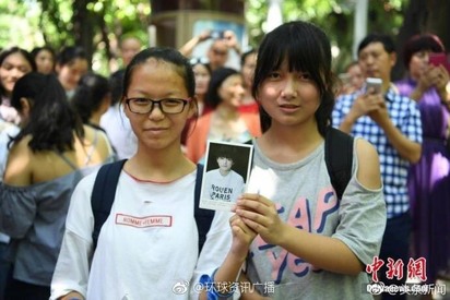 陸偶像王俊凱高考 女粉衝考場遭抗議【圖】 | 她們拿著王俊凱照片站在考場外。