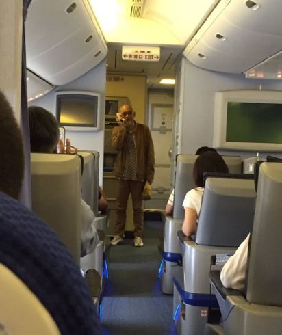 【影】飛機誤點乘客暴怒 創作歌手"開唱解危" | 日本歌手松山千春機上開唱。