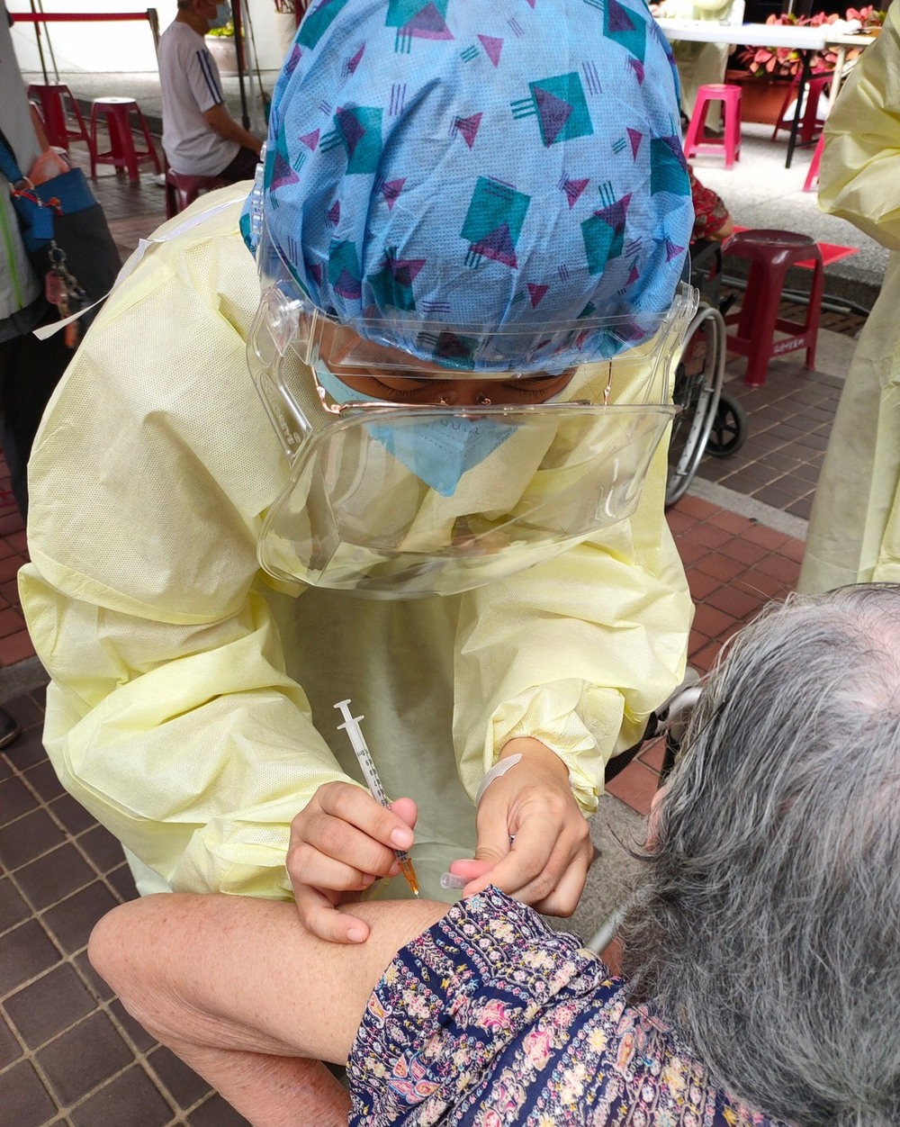 暖！ 台南衛生所主秘公主抱96歲阿嬤進去打疫苗 | (南市府提供)