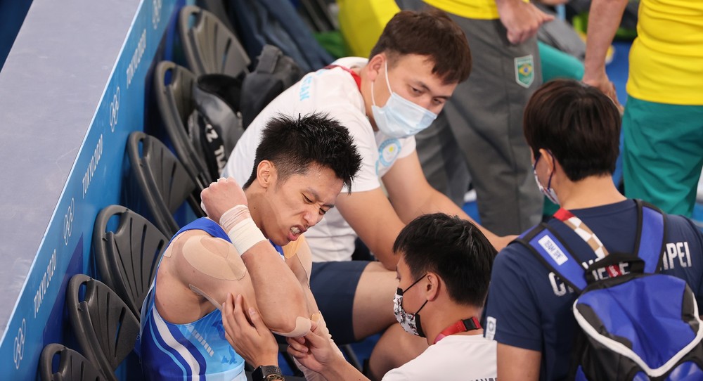 （在體操男子全能決賽中不慎受傷的選手李智凱，防護員立即協助包紮，幸好傷勢沒有大礙。／翻攝自臉書「蔡英文 Tsai Ing-wen」。）
