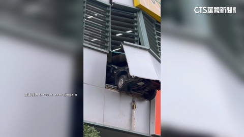 8旬駕駛暴衝撞破停車場圍牆　前輪卡半空掛牆外