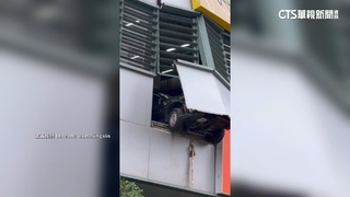 8旬駕駛暴衝撞破停車場圍牆　前輪卡半空掛牆外